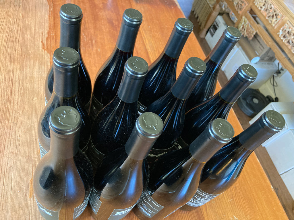 Twelve bottles of Frick Wine sitting on a counter